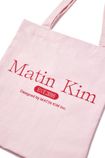 Túi tote unisex với họa tiết in và logo Matin Kim, màu hồng nổi bật.