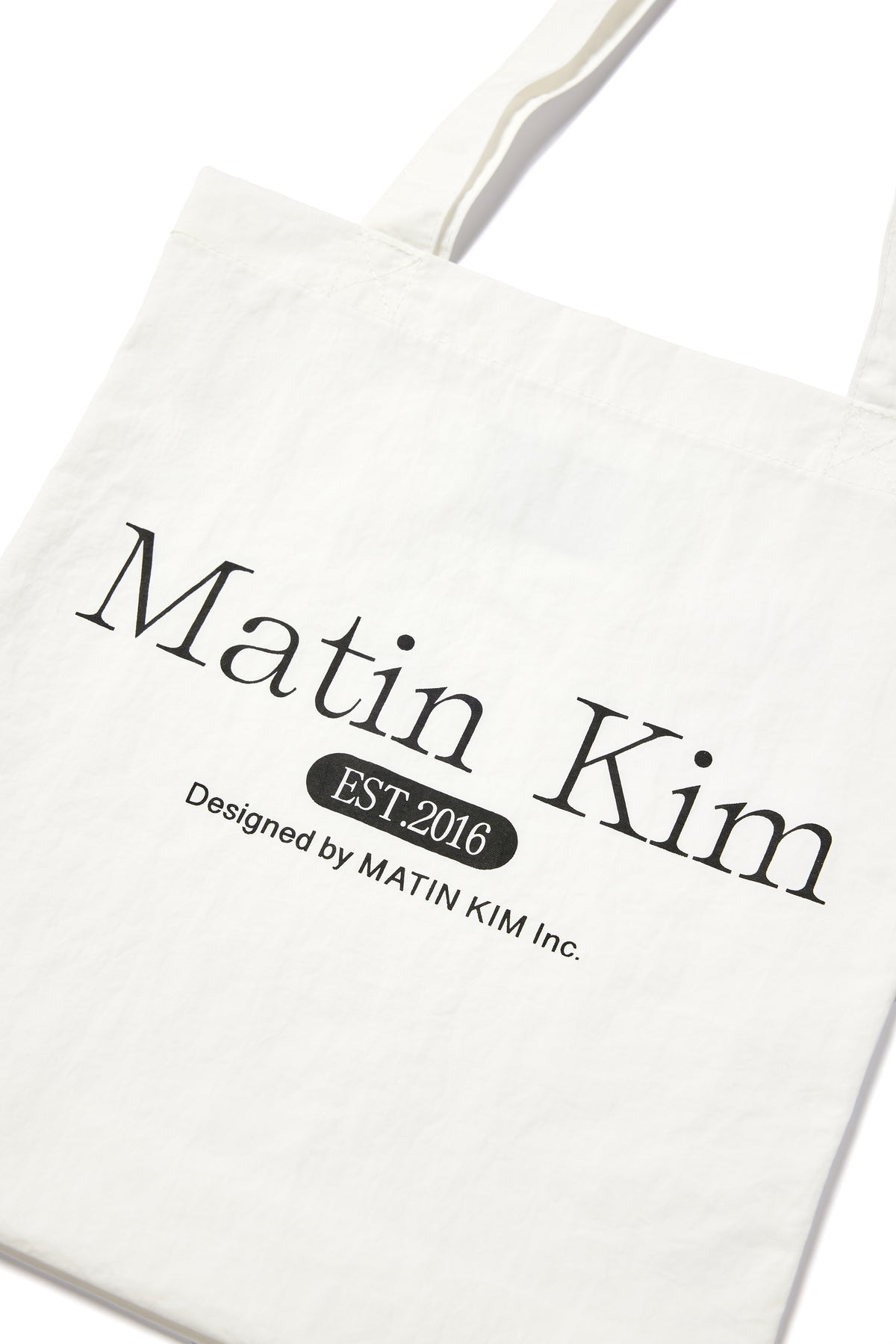 Túi tote unisex với họa tiết chữ in, màu trắng, thiết kế hiện đại.