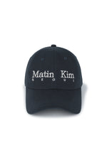 Mũ bóng chày unisex màu navy, vành cong, phom cứng, in logo Matin Kim ở mặt trước và dây strapback phía sau.