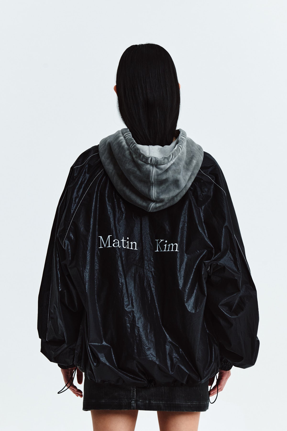 Áo khoác nữ oversize với logo Matin Kim, cổ áo thẳng, tay dài và thiết kế tinh tế.