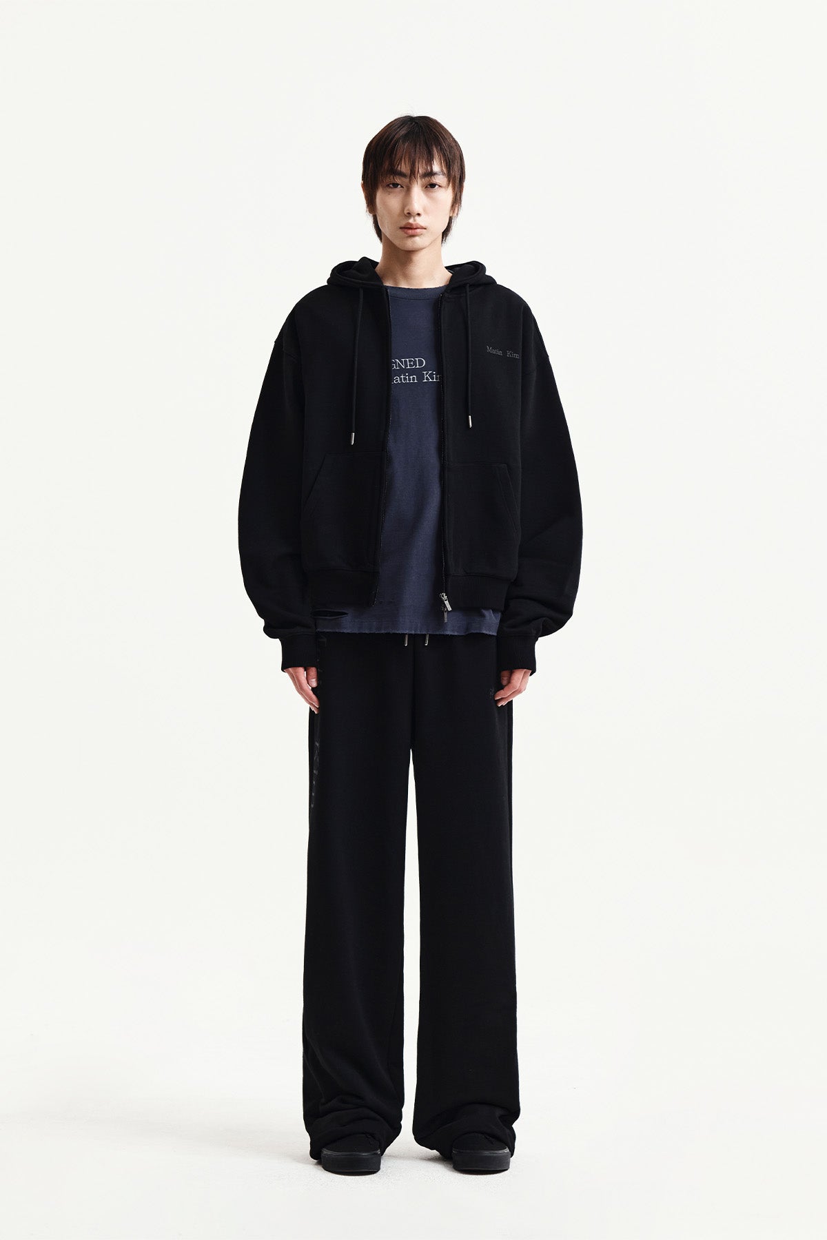 Quần nỉ unisex đen với logo Matin Kim và thiết kế thoải mái.