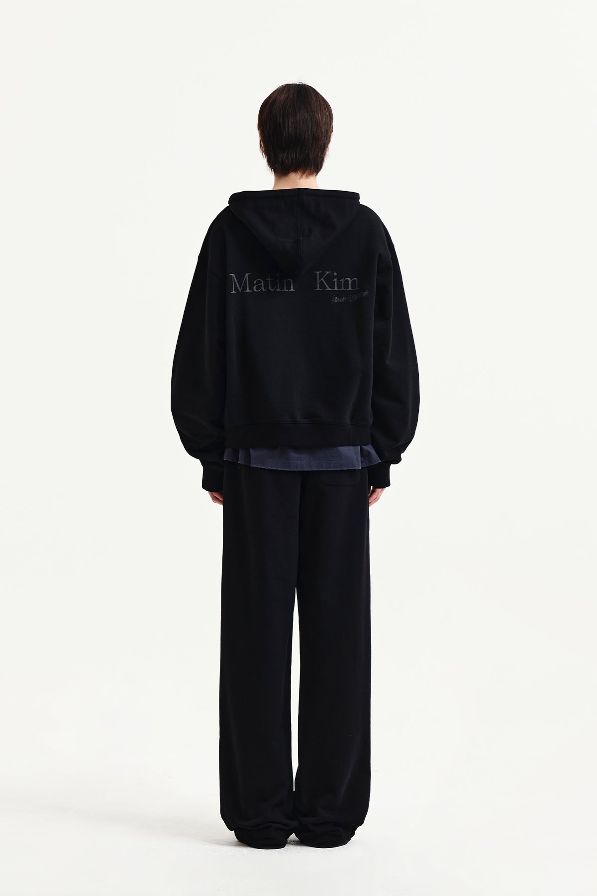 Quần nỉ unisex đen với logo Matin Kim và thiết kế thoải mái.