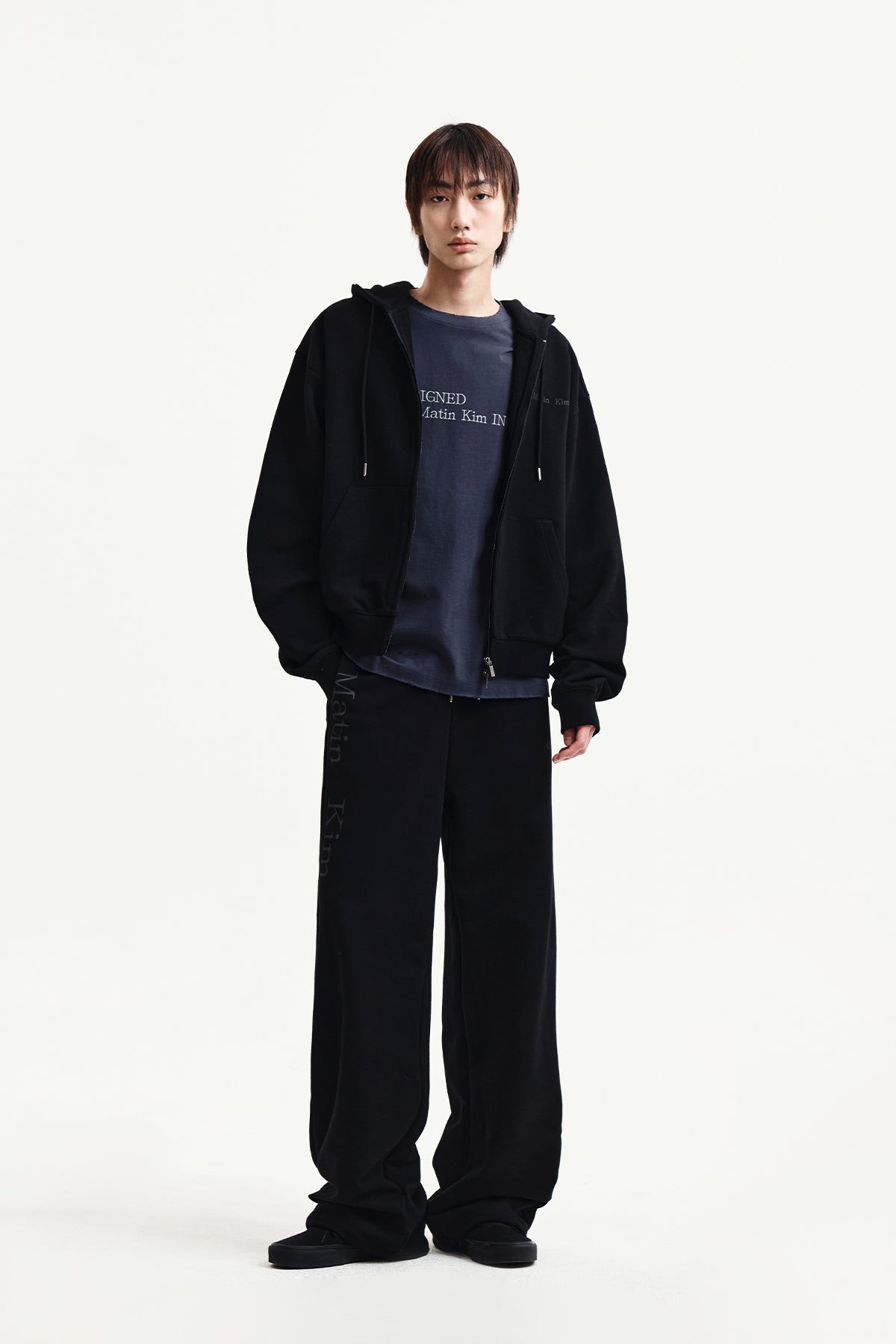 Quần nỉ unisex đen với logo Matin Kim và thiết kế thoải mái.