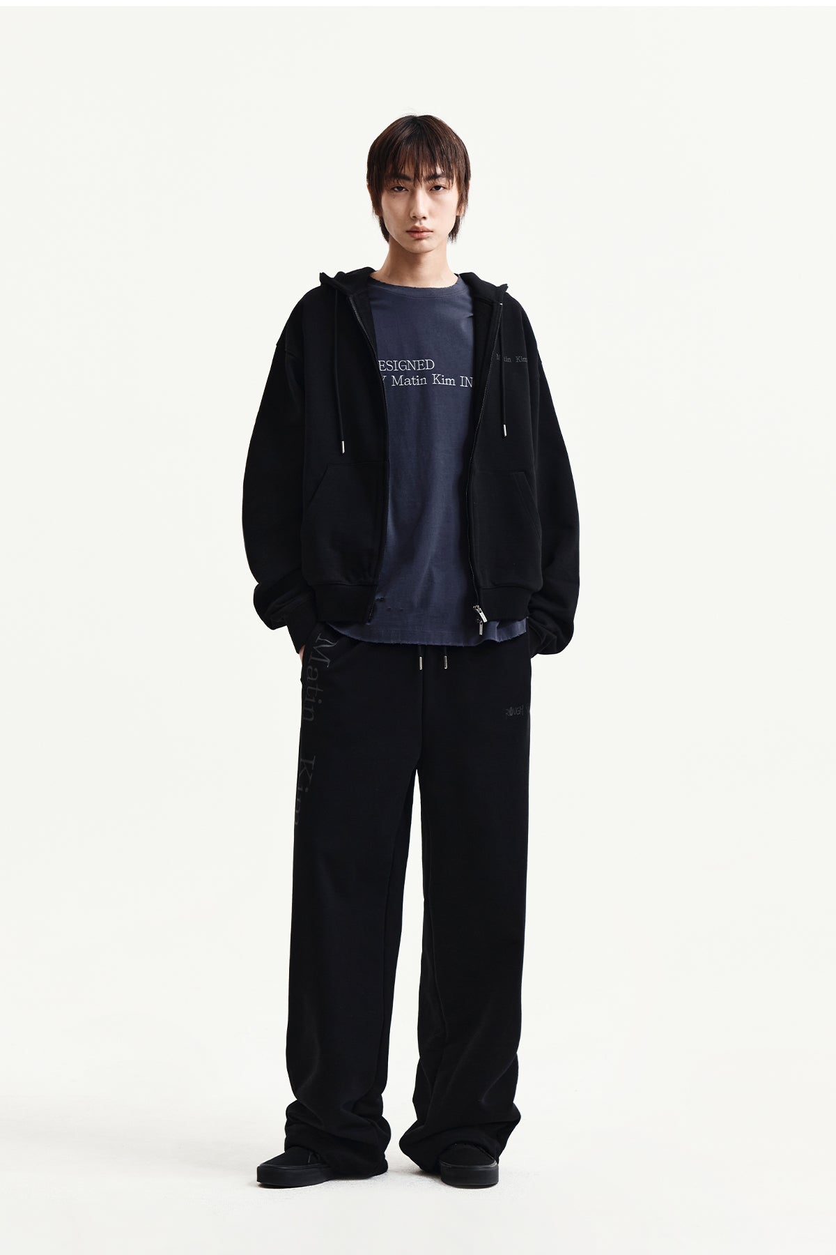 Quần nỉ unisex đen với logo Matin Kim và thiết kế thoải mái.