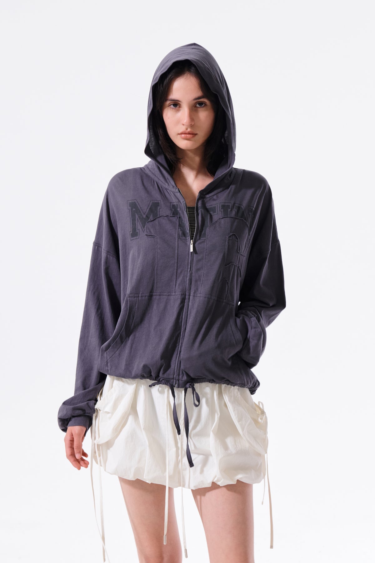 Áo khoác nữ với thiết kế hiện đại, logo Matin Kim thêu, chất liệu cotton mềm mại, và túi kangaroo tiện lợi.