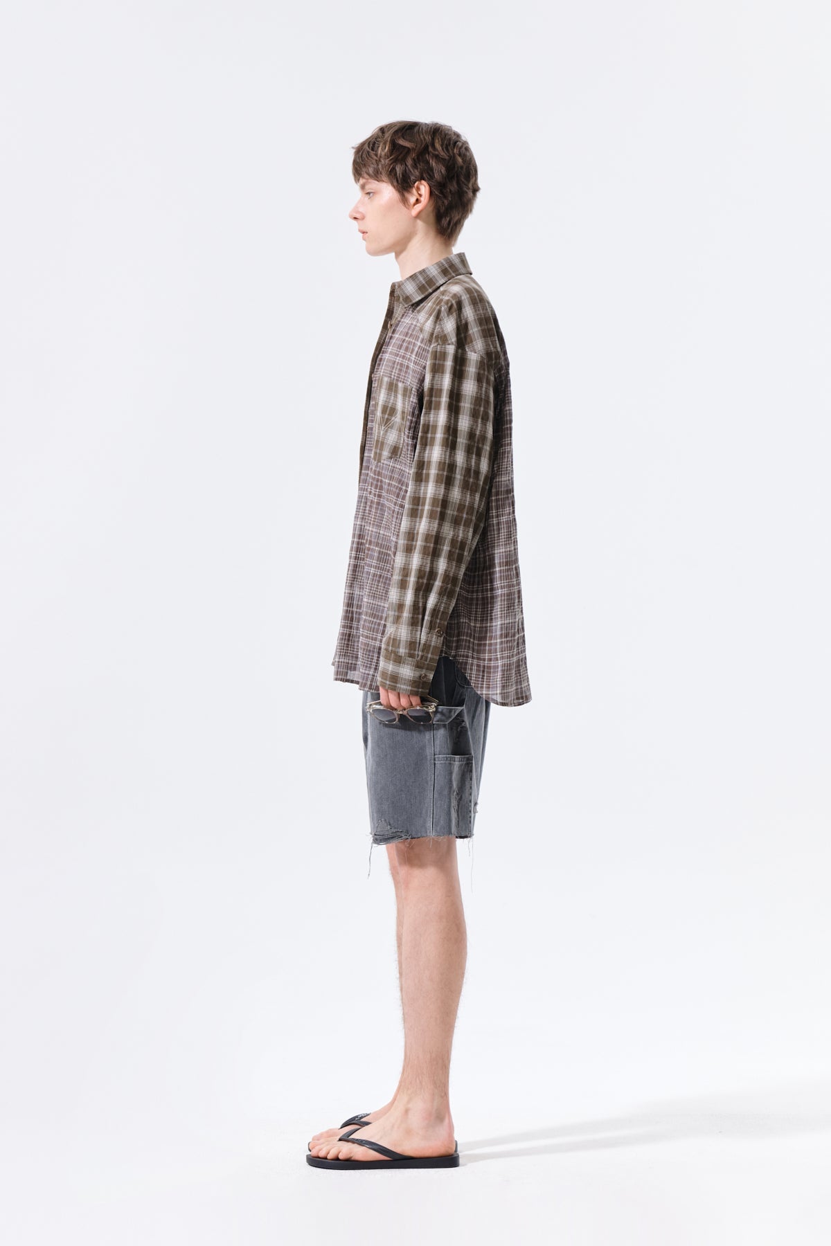 Áo sơ mi unisex với họa tiết caro, cổ sơ mi và tay cài nút, kiểu dáng oversize.