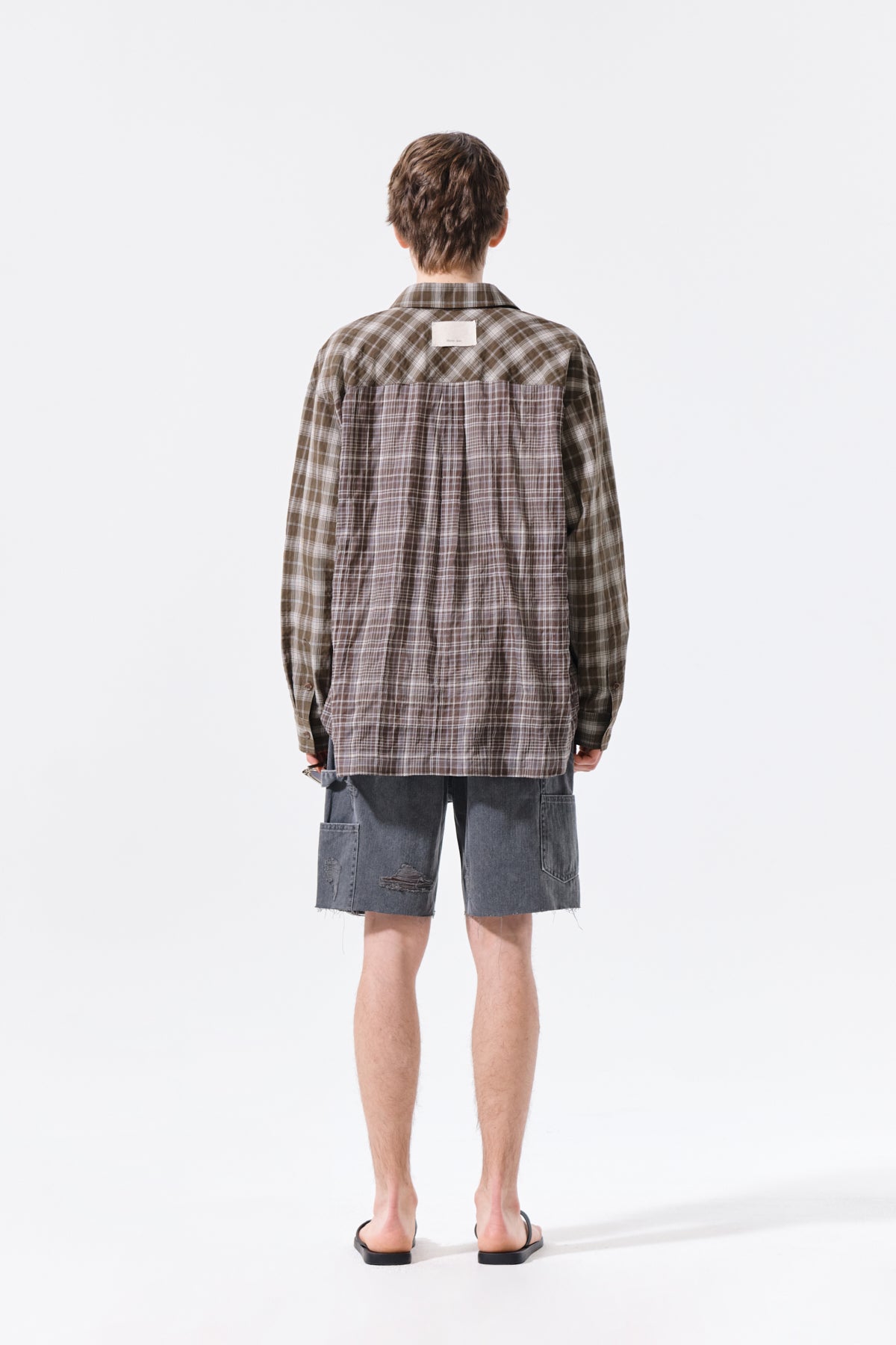 Áo sơ mi unisex với họa tiết caro, cổ sơ mi và tay cài nút, kiểu dáng oversize.