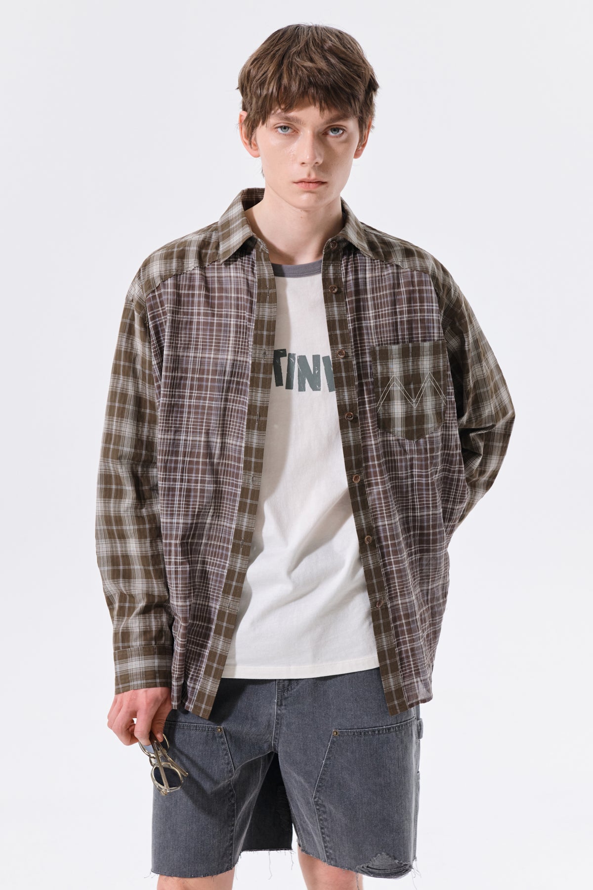 Áo sơ mi unisex với họa tiết caro, cổ sơ mi và tay cài nút, kiểu dáng oversize.