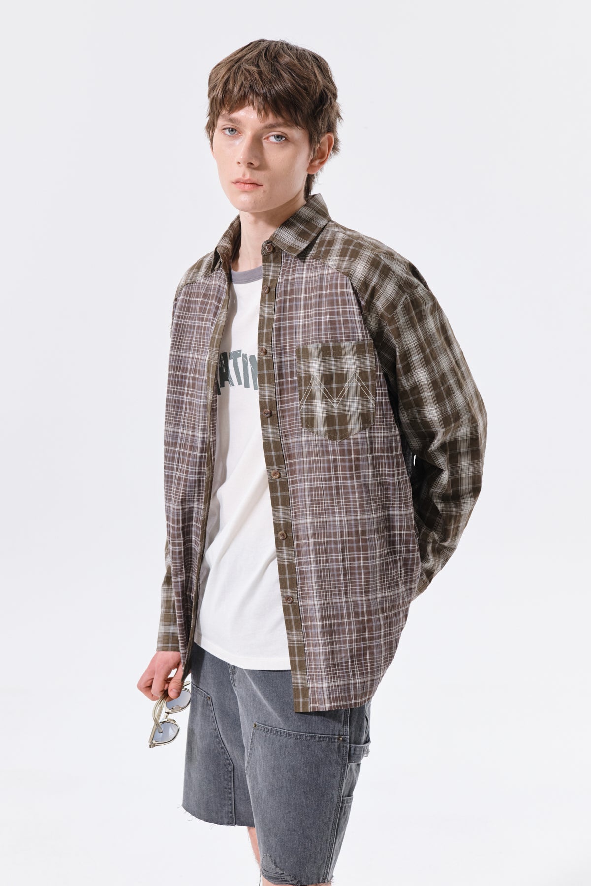 Áo sơ mi unisex với họa tiết caro, cổ sơ mi và tay cài nút, kiểu dáng oversize.