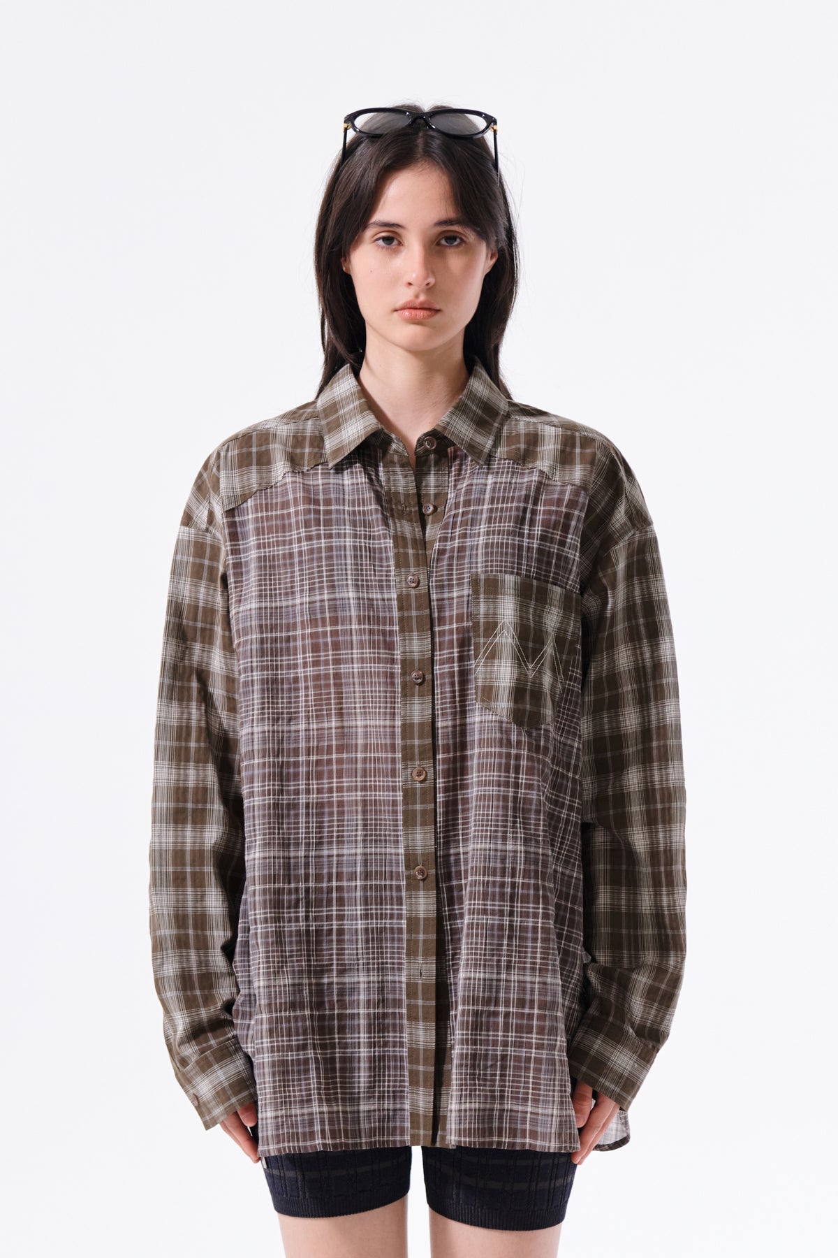 Áo sơ mi unisex với họa tiết caro, cổ sơ mi và tay cài nút, kiểu dáng oversize.