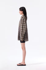 Áo sơ mi unisex với họa tiết caro, cổ sơ mi và tay cài nút, kiểu dáng oversize.