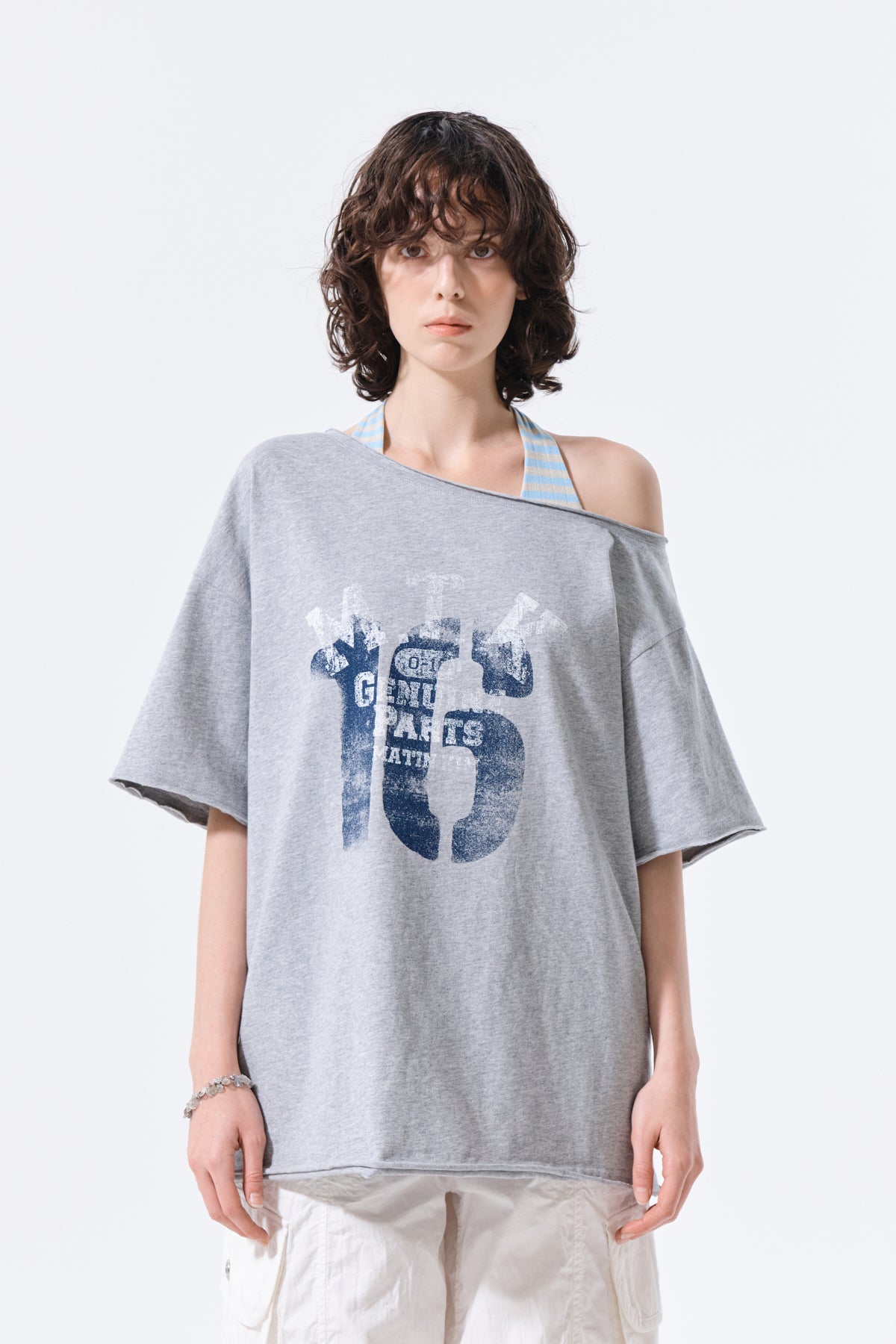 Áo oversize nữ với họa tiết in graphic và thiết kế bất đối xứng.