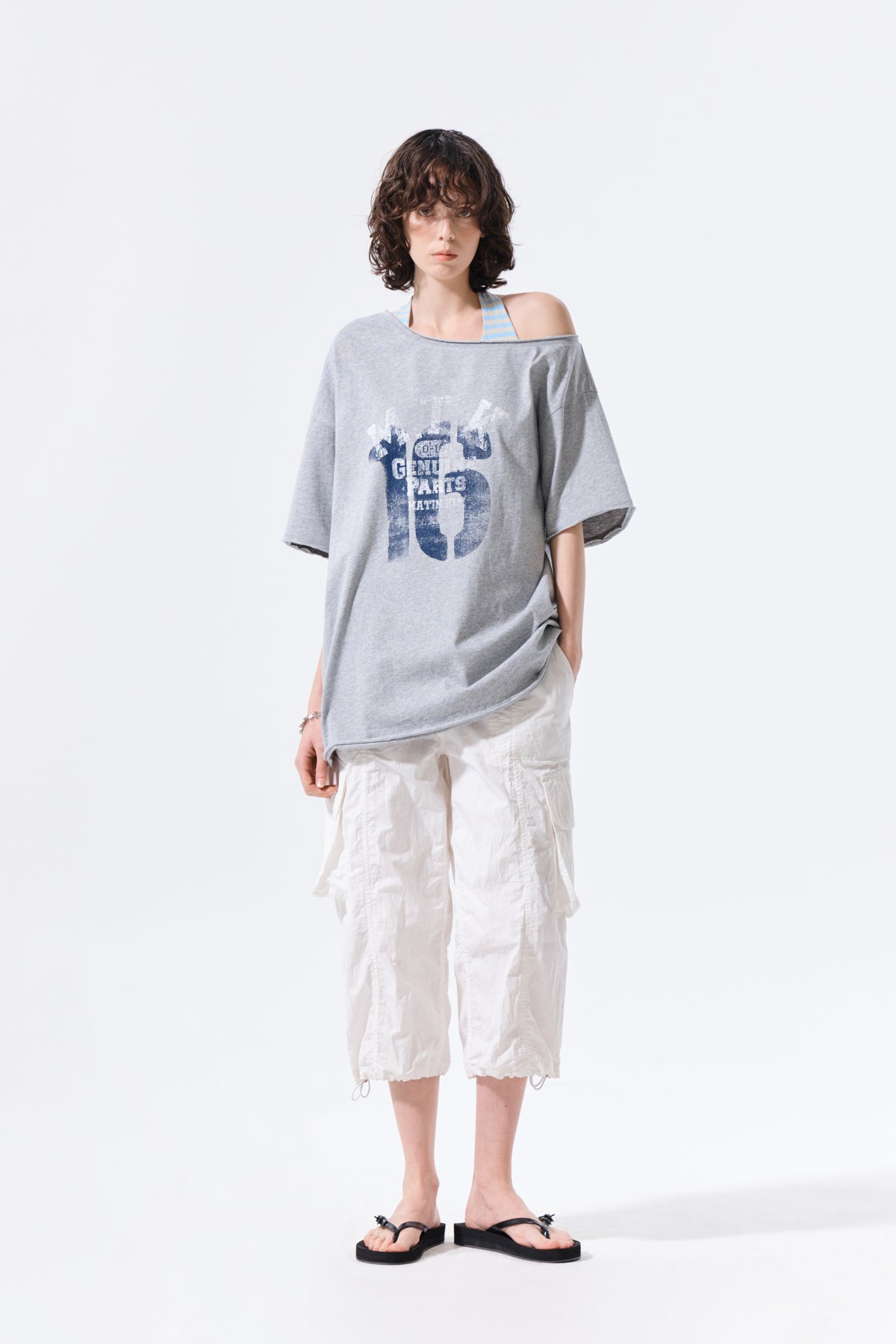 Áo oversize nữ với họa tiết in graphic và thiết kế bất đối xứng.