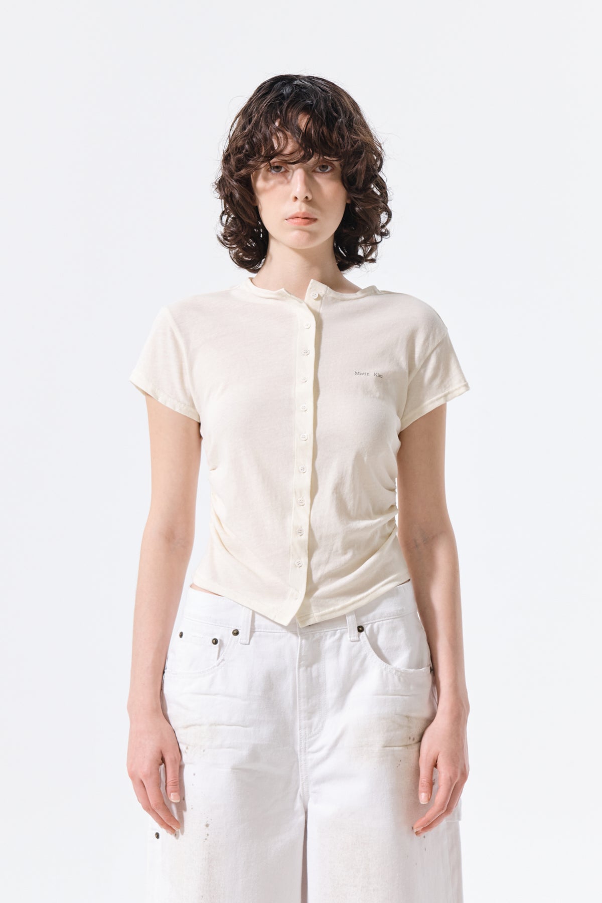 Áo blouse nữ với chi tiết nhún rút và nút, kiểu dáng slim fit, tay ngắn, cổ tròn.