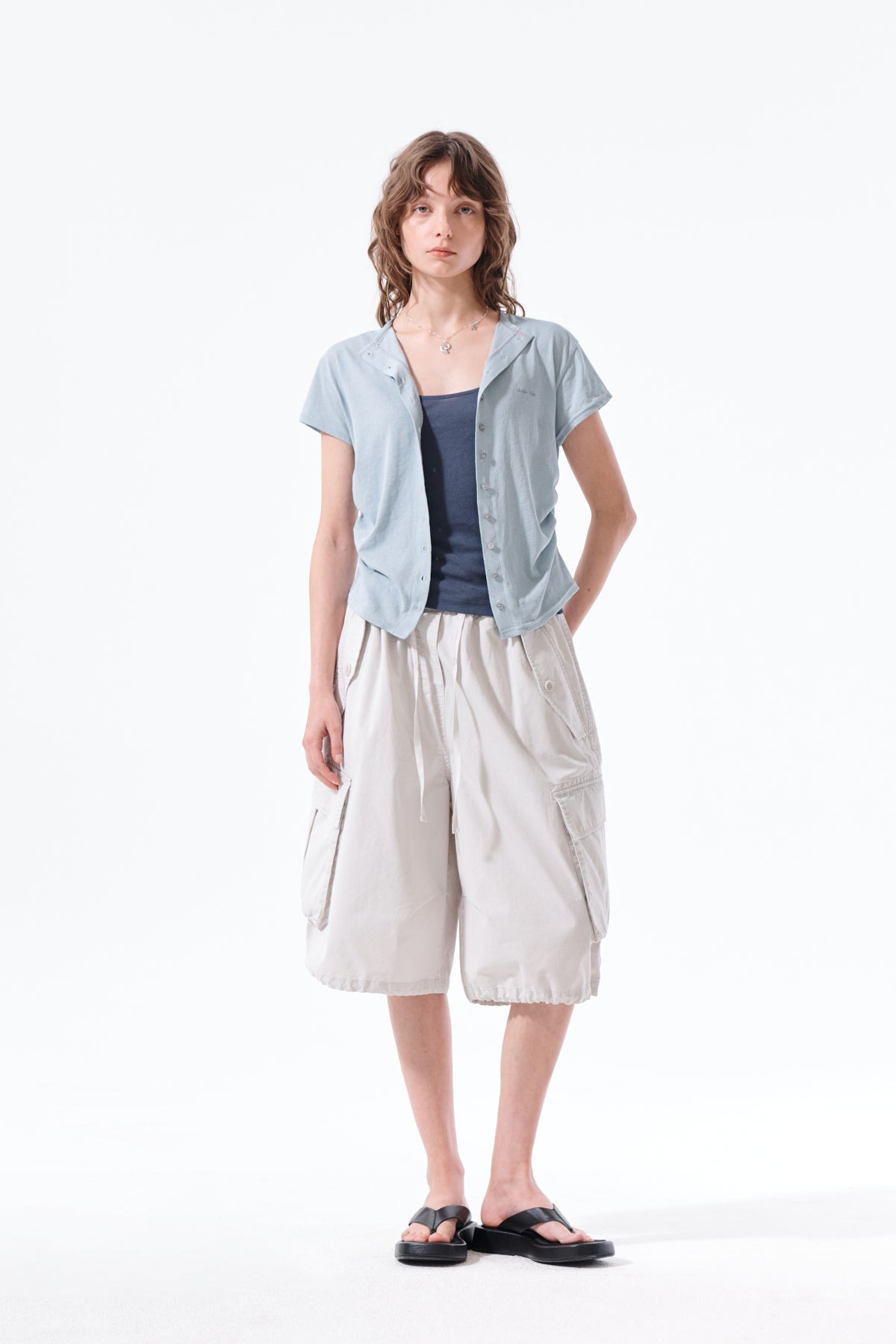 Áo blouse nữ cổ bẻ, tay ngắn, có nút, chi tiết nhún rút, màu xanh nhạt.