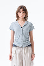 Áo blouse nữ cổ bẻ, tay ngắn, có nút, chi tiết nhún rút, màu xanh nhạt.
