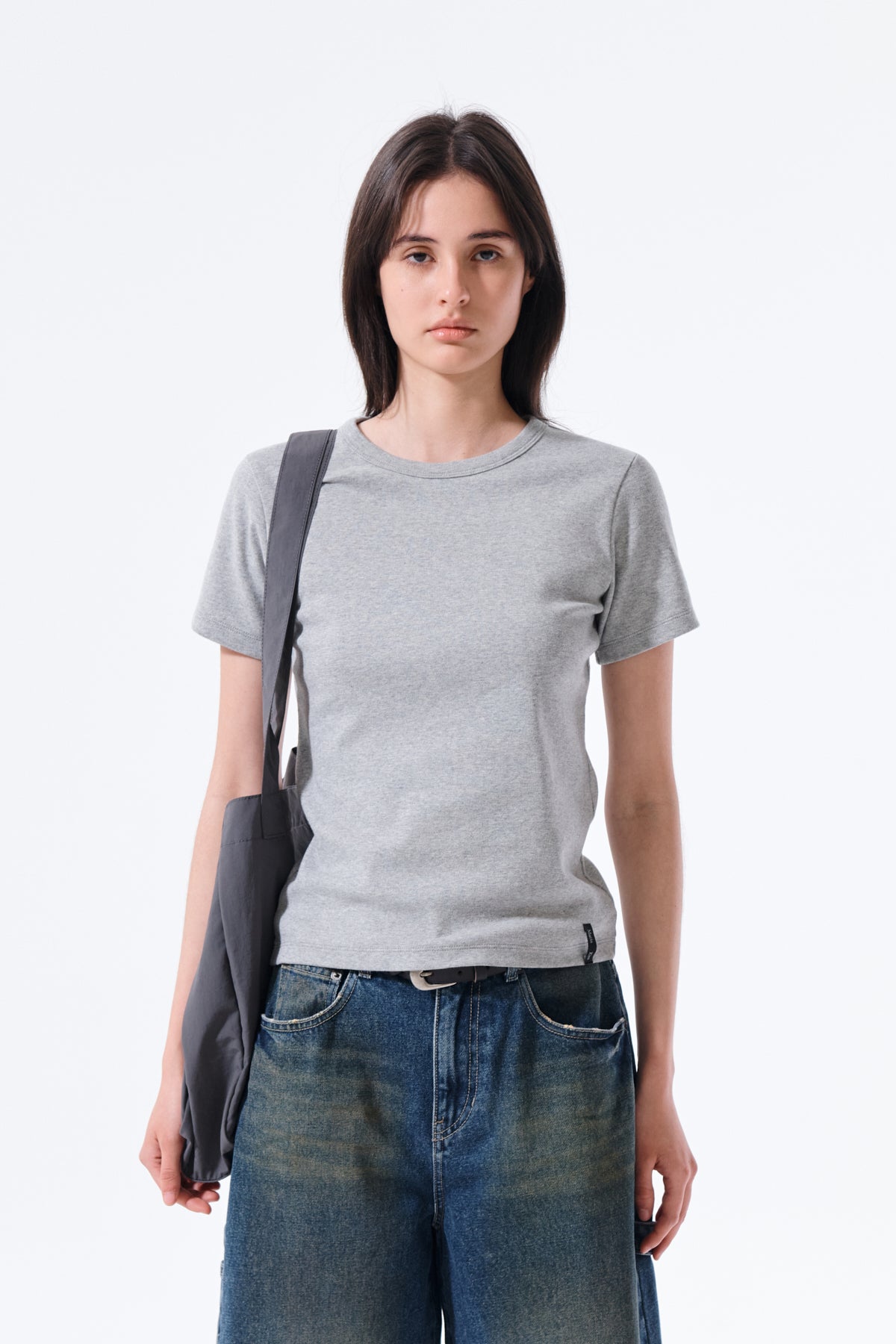 Áo top slim fit nữ màu xám với thiết kế cổ tròn và tay ôm, đường may tinh tế.