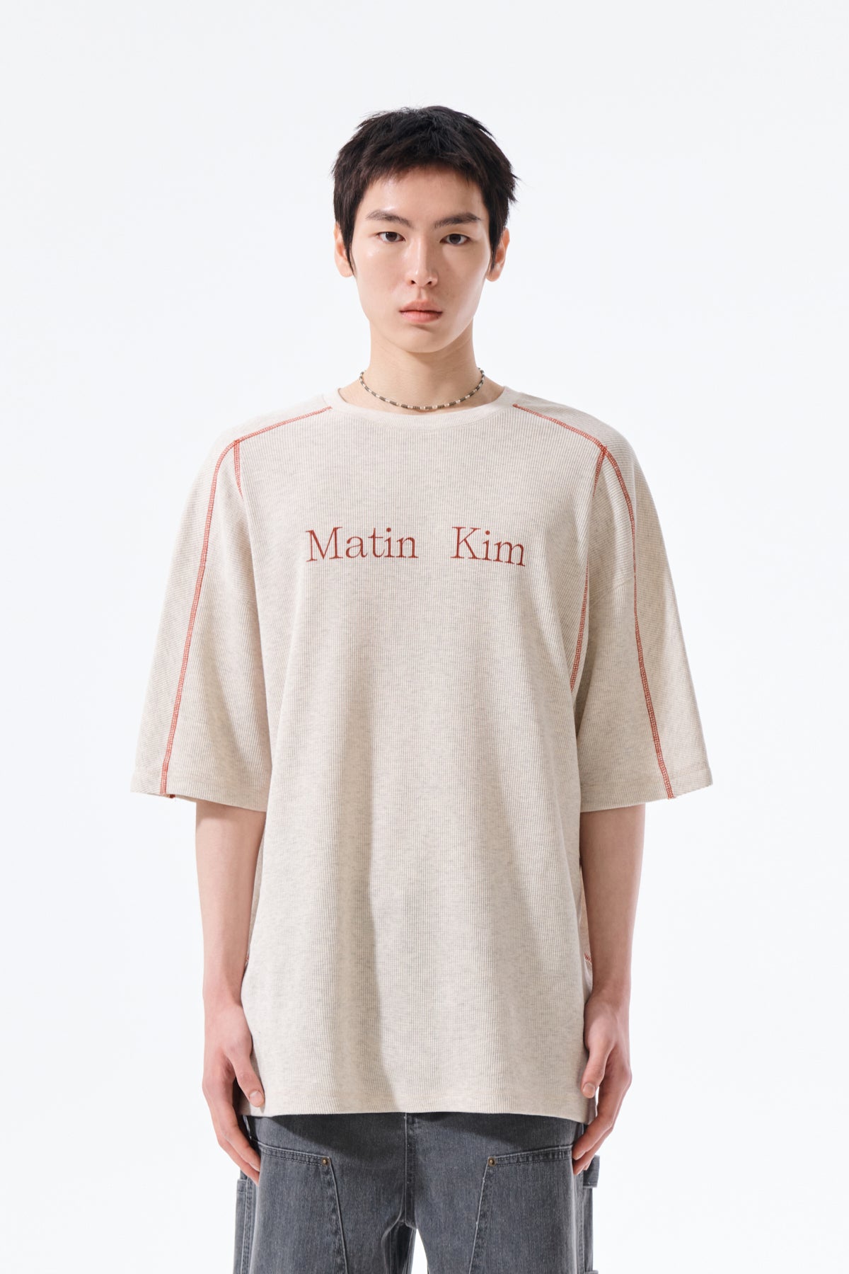 Áo top nam với cổ tròn, tay ngắn và logo Matin Kim, làm từ cotton thoáng khí.