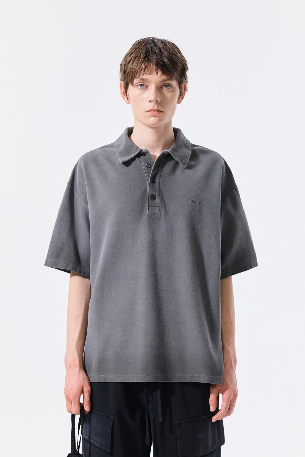 Áo sơ mi nam cổ polo, tay ngắn, màu than, có logo Matin Kim ở ngực trái.