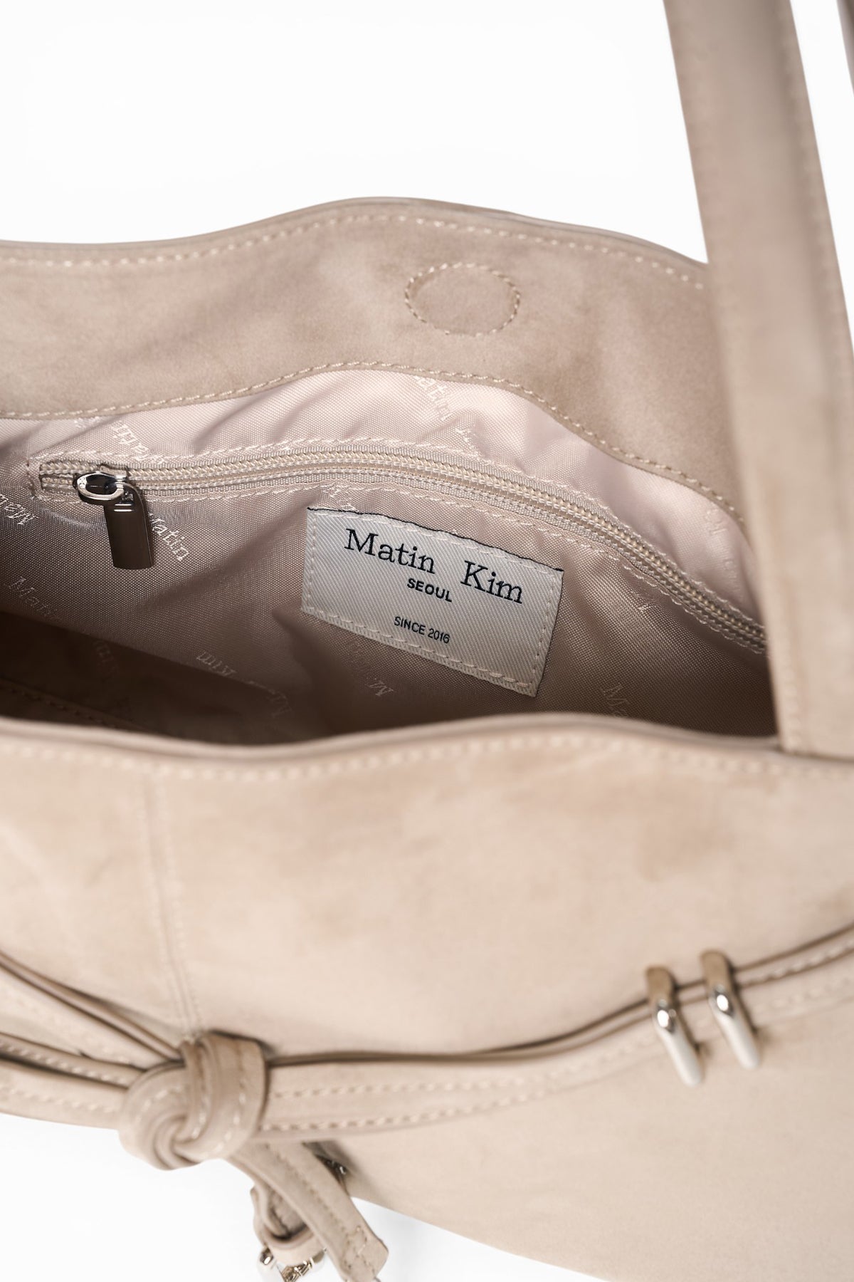 Túi đeo vai dây ngắn màu beige, thân túi định hình góc cạnh, khóa nam châm, dành cho nữ.