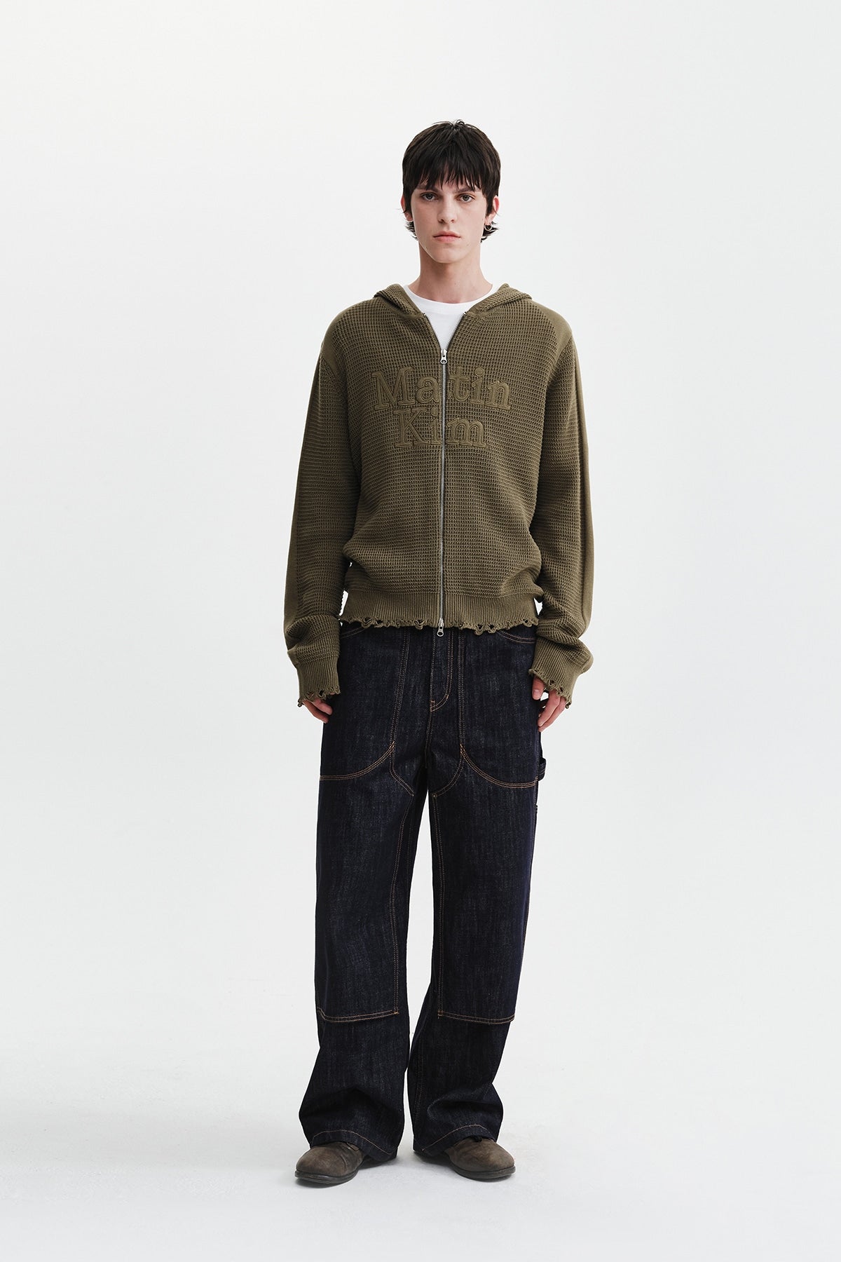 Áo sơ mi unisex màu khaki có mũ trùm, khóa kéo giữa trước, tay dài và logo Matin Kim