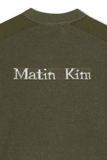 Áo sơ mi nam cotton màu khaki, tay dài, cổ tròn, có chữ ở lưng trên và hai túi hông.
