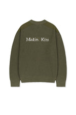 Áo sơ mi nam cotton màu khaki, tay dài, cổ tròn, có chữ ở lưng trên và hai túi hông.
