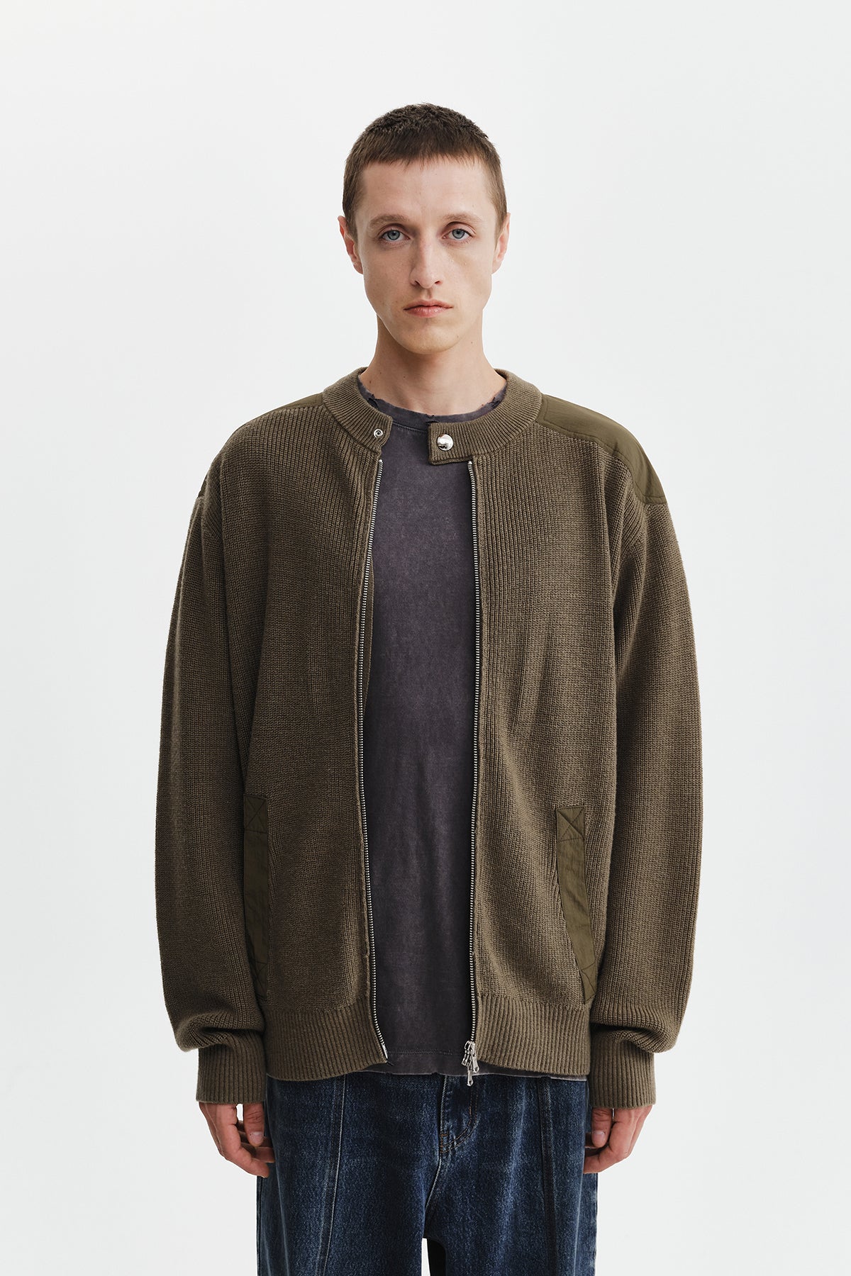 Áo sơ mi nam cotton màu khaki, tay dài, cổ tròn, có chữ ở lưng trên và hai túi hông.