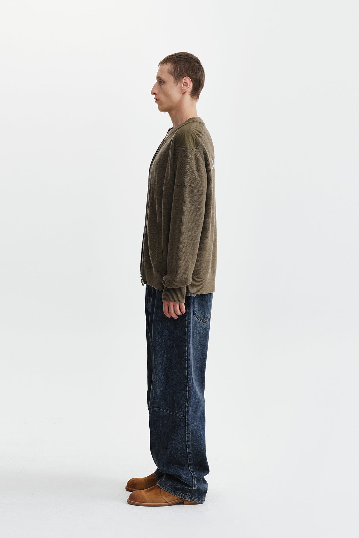 Áo sơ mi nam cotton màu khaki, tay dài, cổ tròn, có chữ ở lưng trên và hai túi hông.