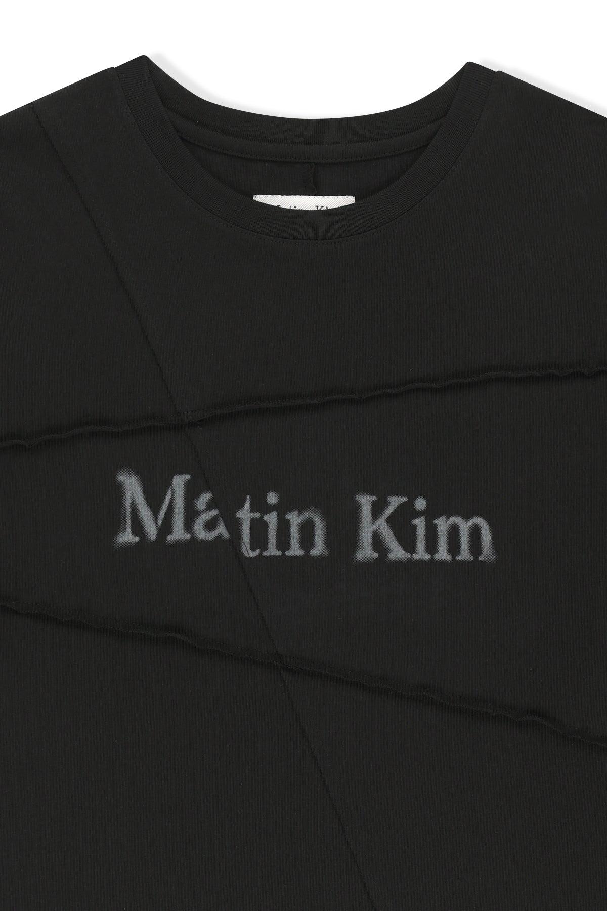 Áo top unisex với đường cắt chéo và logo Matin Kim, phom hộp màu đen.