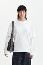 Áo blouse nữ cotton màu trắng, cổ tròn, tay dài, dáng regular dài đến hông, thiết kế khoét lưng.